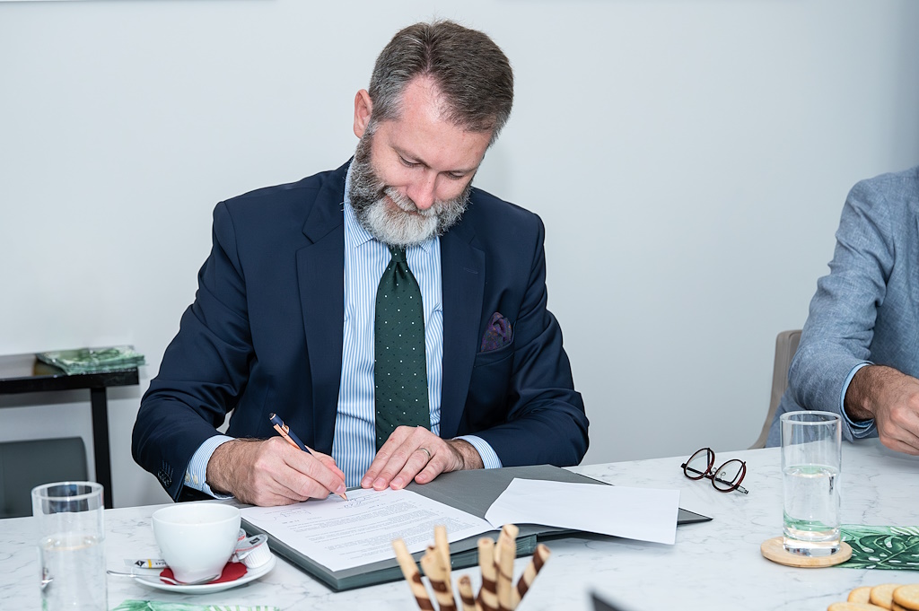 Děkan FSV UK Tomáš Karásek podepisuje memorandum.